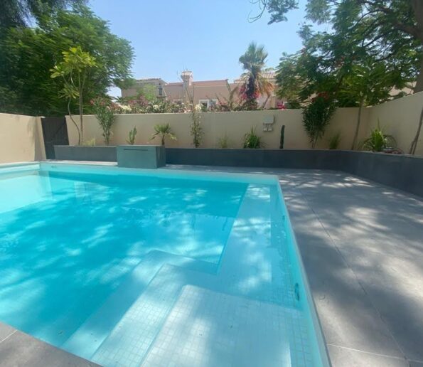 Outdoor swimming pool with landscaping and seating in Dubai